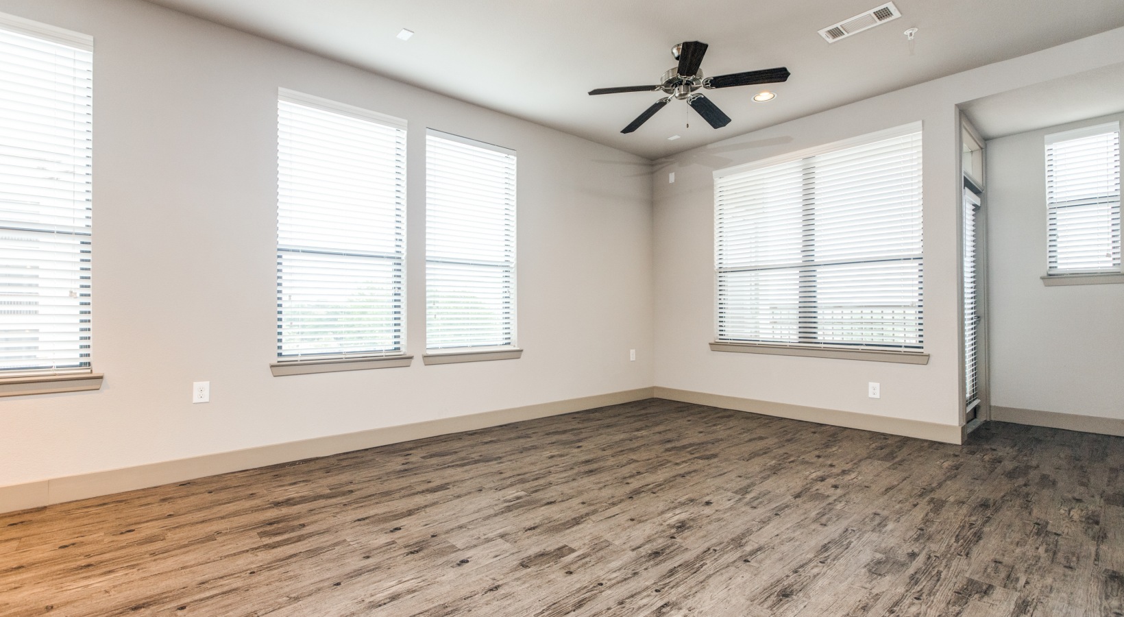 empty room with ceiling fan and hardwood floors at The  Carson @ Twin Creeks