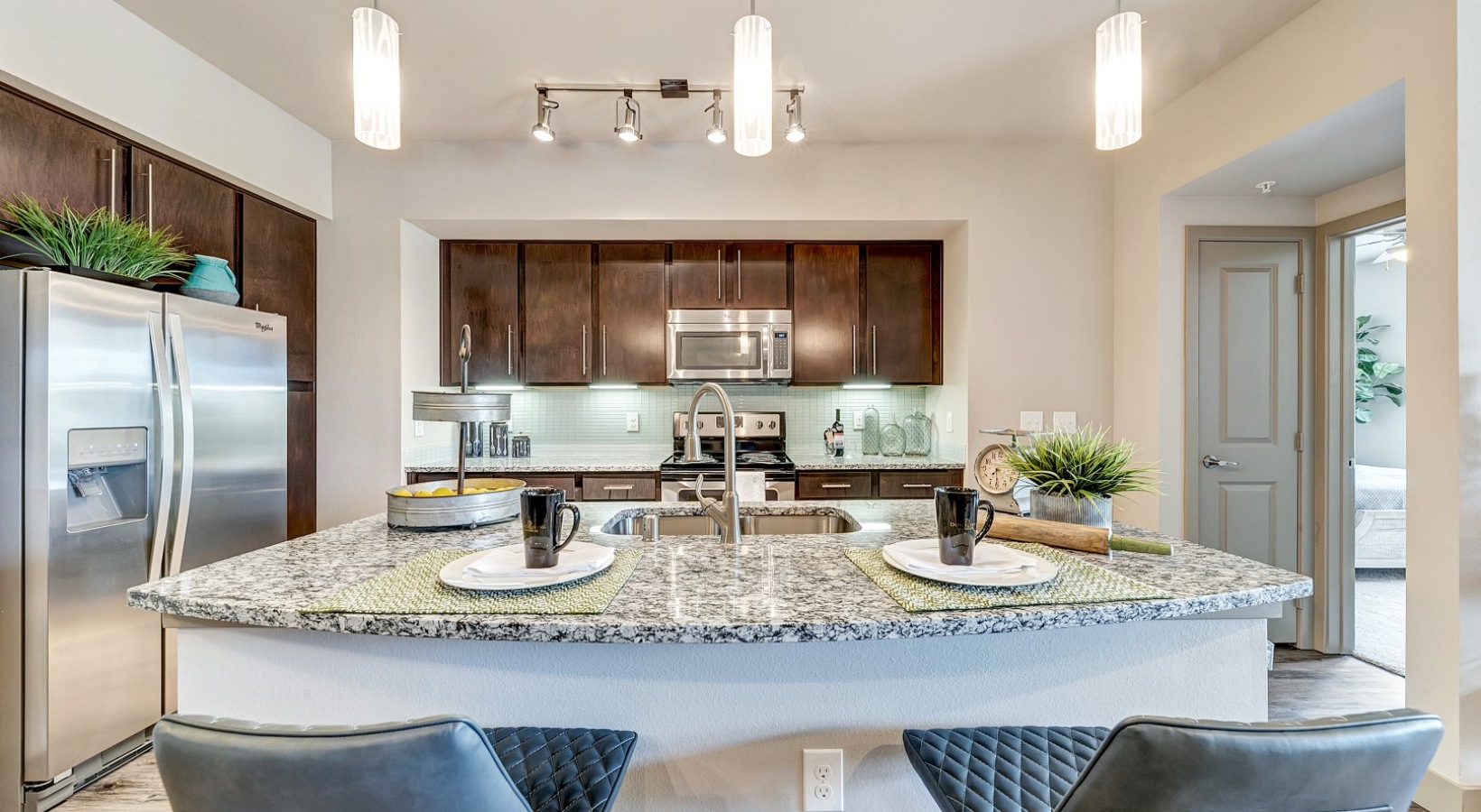 a kitchen with granite counter tops and stainless steel appliances at The  Carson @ Twin Creeks