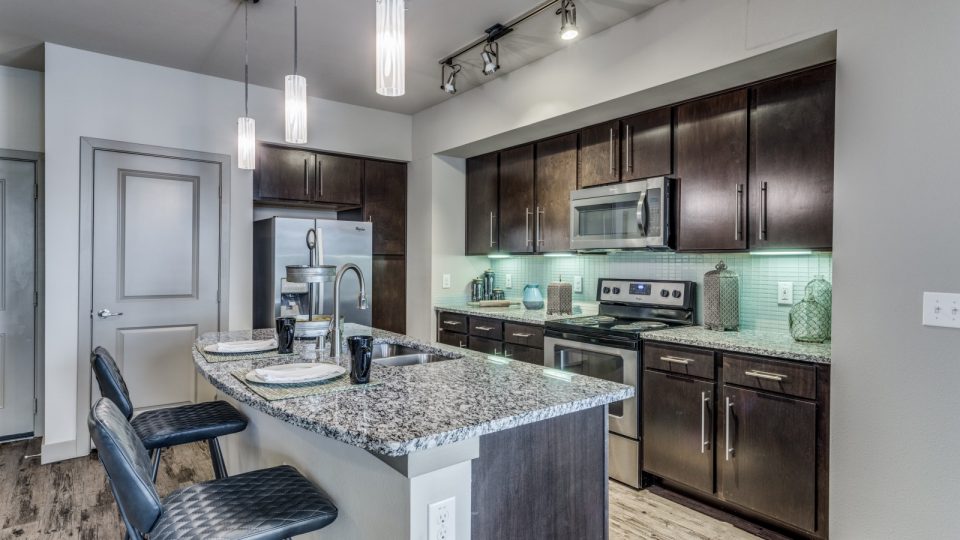 a kitchen with stainless steel appliances and granite counter tops at The  Carson @ Twin Creeks