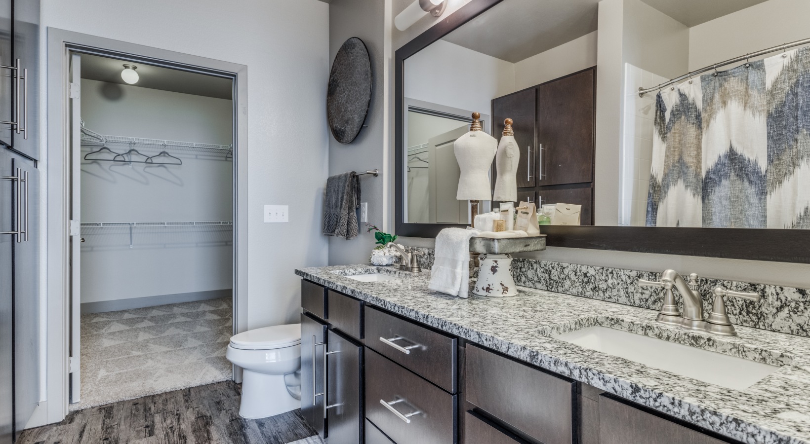 a bathroom with granite counter tops and a large mirror at The  Carson @ Twin Creeks