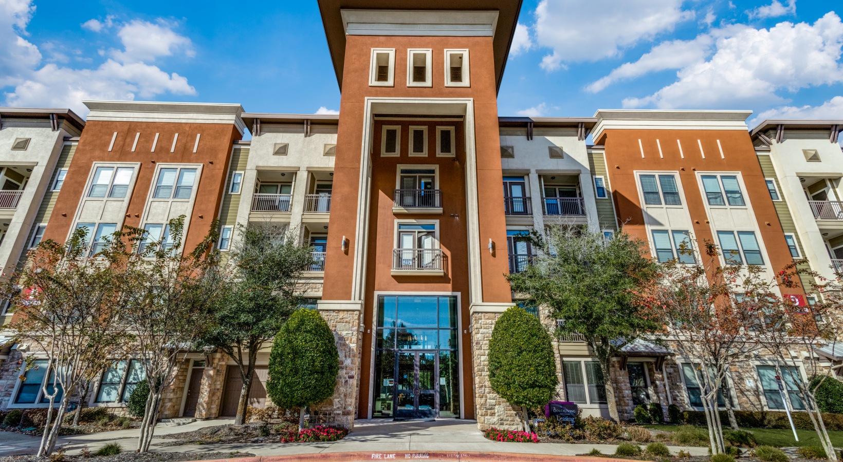 the front entrance to an apartment complex in dallas at The  Carson @ Twin Creeks